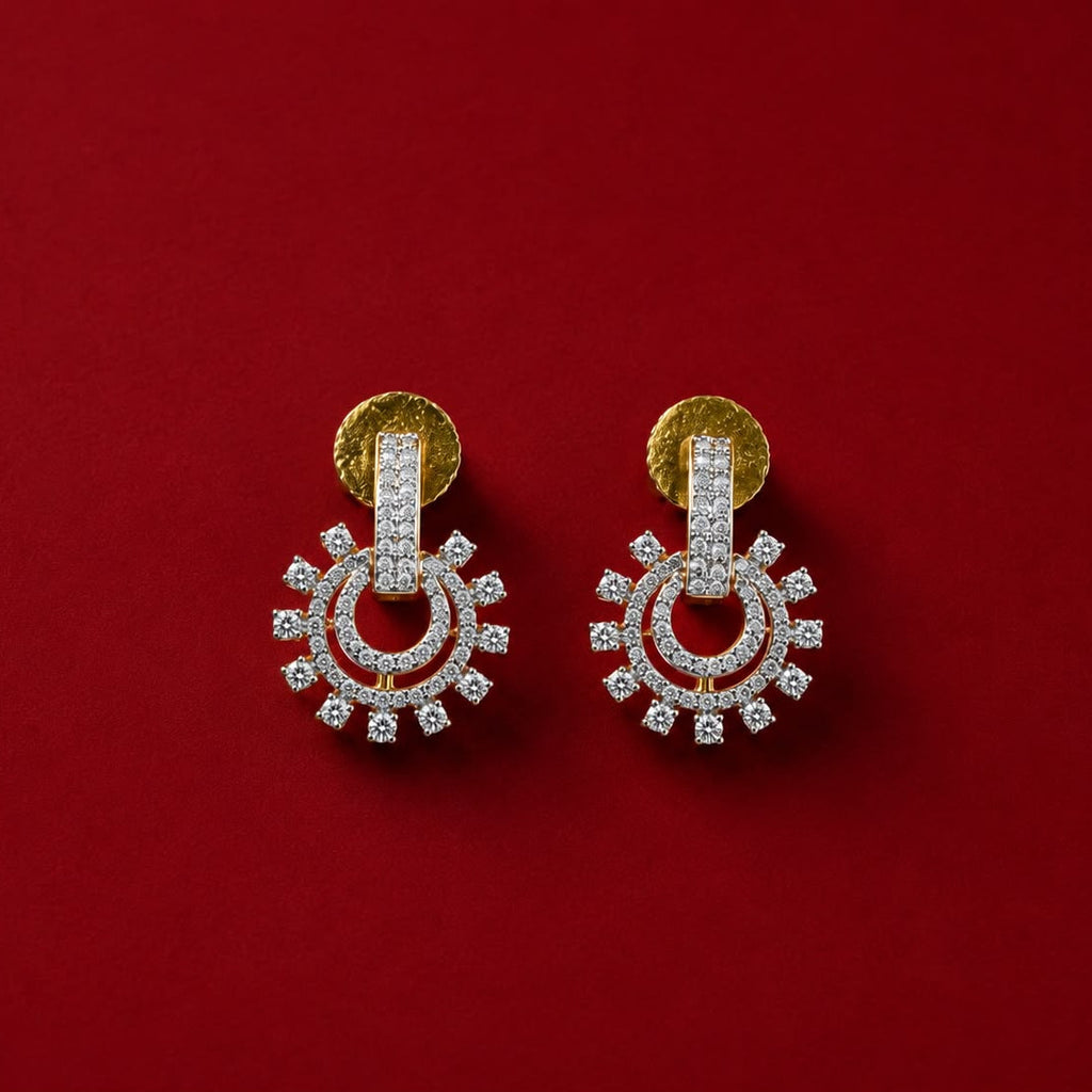 A pair of gold and silver-toned earrings with clear stones, arranged symmetrically on a solid red background.